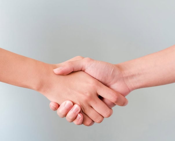 Deux personnes se serrant la main, symbole d'un partenariat Alertify