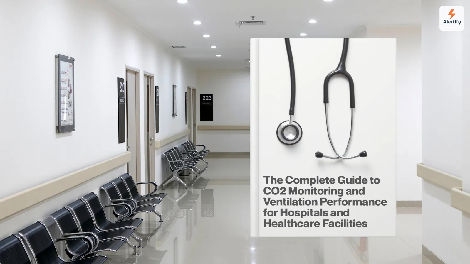 Couloir d'hôpital vide bordé de rangées de chaises d'attente, à côté d'une couverture de guide montrant un stéthoscope